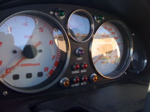 1991 Mazda Miata - Close-up of the dashboard gauges, including the tachometer and speedometer, with various indicator lights visible.