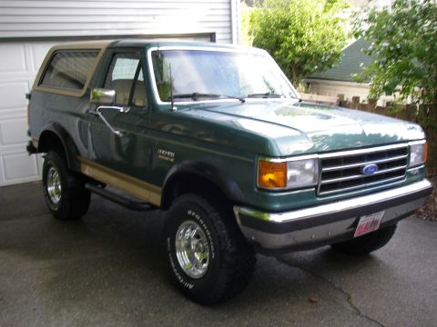 1990 Ford Bronco - 1990 Ford Bronco in a driveway, showing its front and side profile.