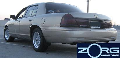 2000 Mercury Grand Marquis - Gold 2000 Mercury Grand Marquis sedan with aftermarket wheels parked outdoors.