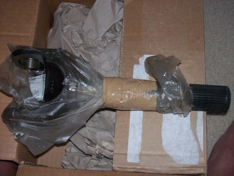 1982 Ford F-100 - A new axle shaft is shown, partially wrapped in plastic and tape, inside a cardboard box.