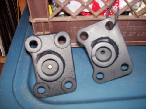 1982 Ford F-100 - Two metal brackets are shown against a blue background with a brown crate in the upper portion of the image.