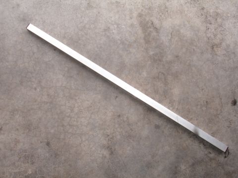 1993 Ford Taurus - A long, thin aluminum bar rests on a textured concrete surface.