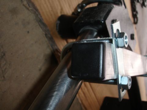1993 Ford Taurus - A close-up view of a metal bracket assembly, showing bolts, nuts, and a protective plastic cap.