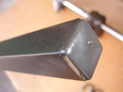 1993 Ford Taurus - A dark gray camera mount, possibly for a vehicle, is shown with water droplets on its surface.