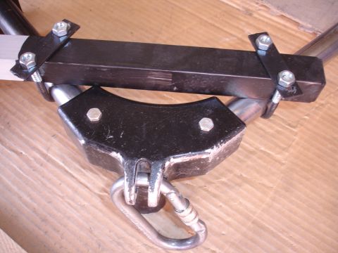 1993 Ford Taurus - Close-up of a metal camera mount bracket with a carabiner, resting on a cardboard surface.