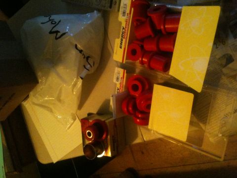 1993 Ford Bronco - Red polyurethane bushings are packaged and ready for installation, with some text visible on the packaging.