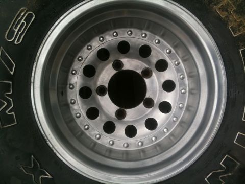 1993 Ford Bronco - Close-up of an aftermarket aluminum wheel and tire assembly, showing its construction and tread pattern.
