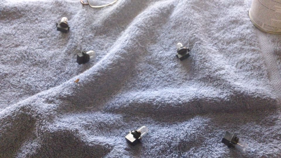 Several small automotive light bulbs scattered on a blue towel