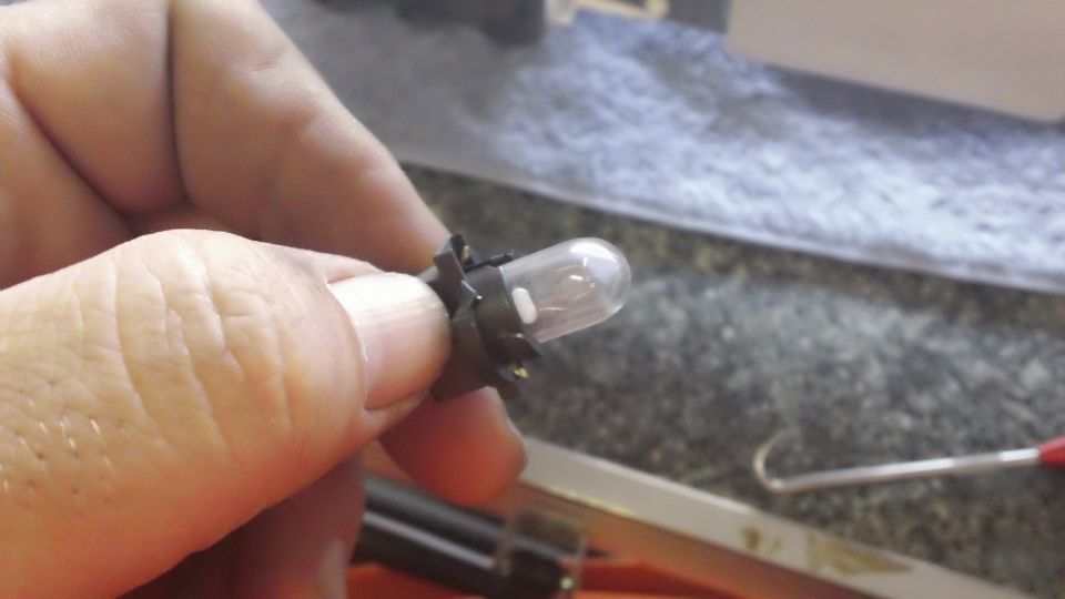 Instrument cluster bulb held by fingers