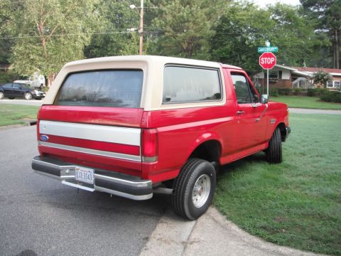 1989 Ford Bronco - This 1989 Ford Bronco is parked on a residential street next to a grassy lawn.