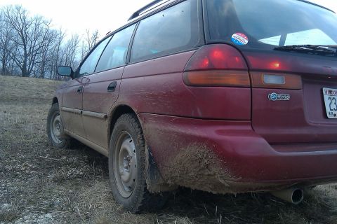 1998 Subaru Legacy - This red wagon is caked in mud, suggesting it has been driven off-road.