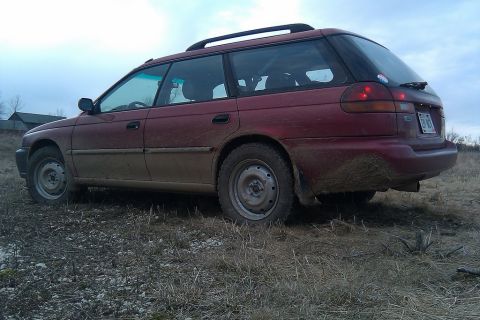 1998 Subaru Legacy - This 1998 Subaru Legacy wagon is seen from a three-quarter front view, covered in mud.