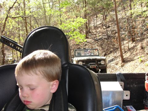 1967 Ford Mustang - Two off-road vehicles on a dirt road, with a child sleeping in the foreground.
