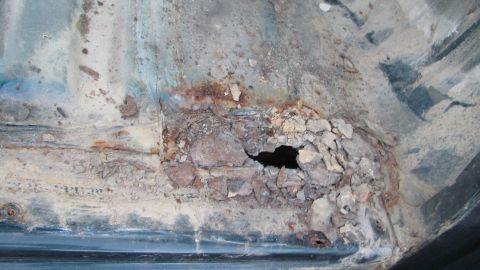1992 Ford Bronco - Significant rust damage has created a hole in the vehicle's floor pan.