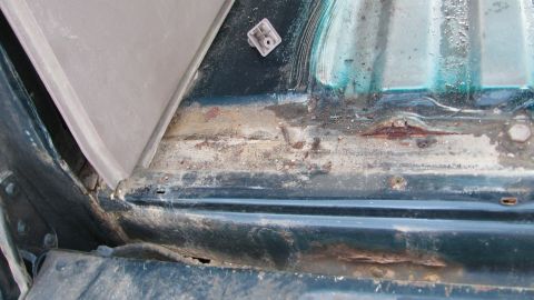 1992 Ford Bronco - Close-up view of rust and corrosion on an interior vehicle panel.