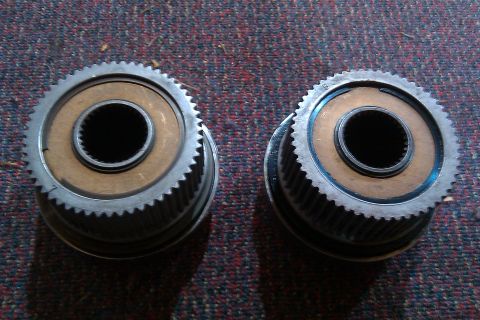1993 Ford F-150 - Close-up view of two geared hubs, possibly for a vehicle's drivetrain, resting on a textured surface.