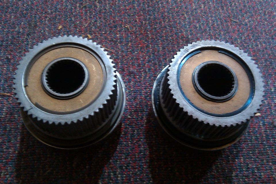 Two geared hubs with splined centers, sitting on a carpeted surface