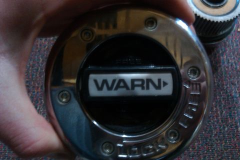1993 Ford F-150 - A chrome Warn locking hub is held in a hand, with text indicating 'WARN' and 'FREE'.