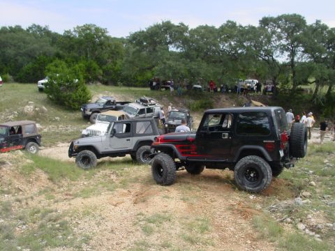 1973 Ford Bronco - Several Jeeps are gathered off-road for an event.