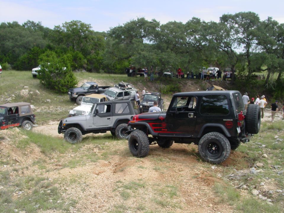 Black Jeep Wrangler with red accents, rear tire visible