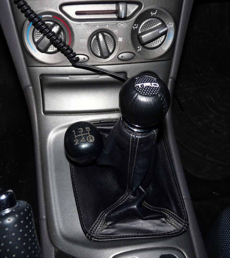 Car interior with a manual gear shifter and TRD shift knob. The gear pattern shows 1, 2, 3, 4, 5, and R