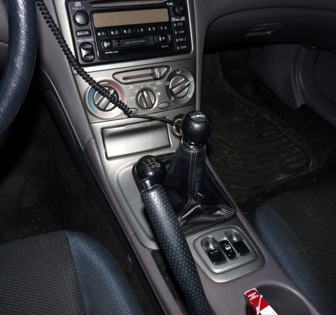 2006 Ford E350 - The interior of a car is shown, a manual transmission shifter and handbrake, along with the center console and radio.