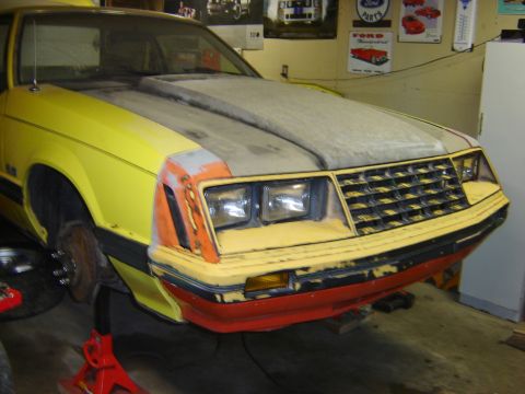 1979 Ford Mustang - Front view of a 1979 Ford Mustang undergoing repairs, showing its distinctive grille and headlights.