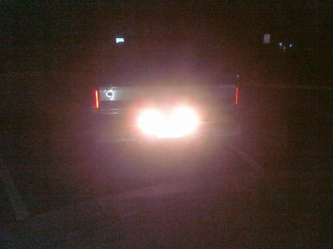 1995 Ford Bronco - The rear of a 1995 Ford Bronco is visible at night, with its brake lights and reverse lights illuminated.