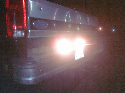 1995 Ford Bronco - Rear view of a 1995 Ford Bronco at night, showing taillights and license plate.