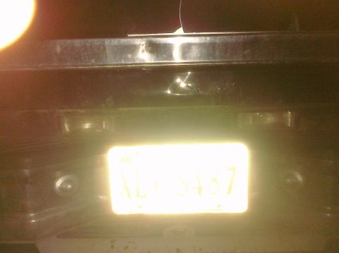 1995 Ford Bronco - The rear of a vehicle is visible, illuminated by its license plate.