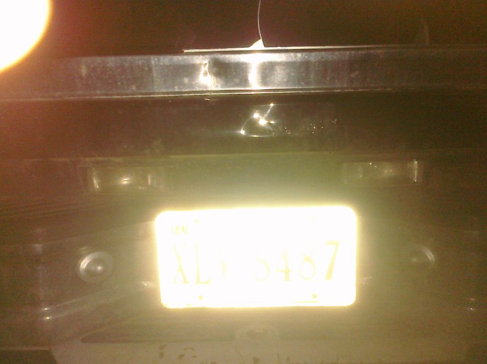Rear of a dark-colored SUV with a bright yellow license plate reading KLY 5457