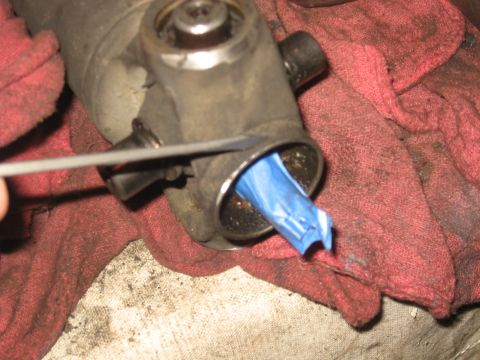 1990 Ford F-250 - A driveshaft U-joint is shown with blue tape inserted into its opening, surrounded by red shop rags.