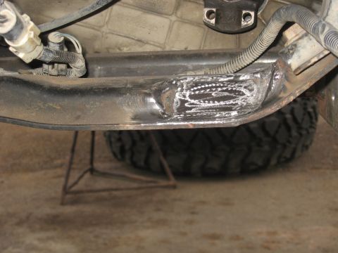 1990 Ford F-250 - Close-up view of a welded repair on a vehicle's frame component, with a tire visible in the background.