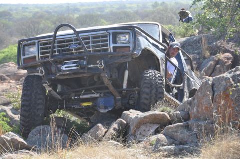 1986 Ford Bronco - This heavily modified 1980s Ford Bronco is shown tackling a challenging rocky trail.