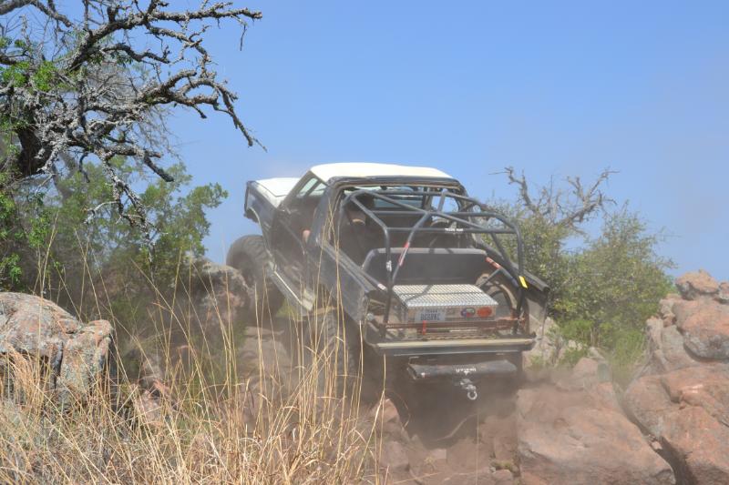 Off-road vehicle with roll cage climbing rocky terrain