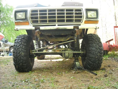 1979 Ford F-150 - The front end of a lifted 1979 Ford F-150 is shown with its suspension and large off-road tires.