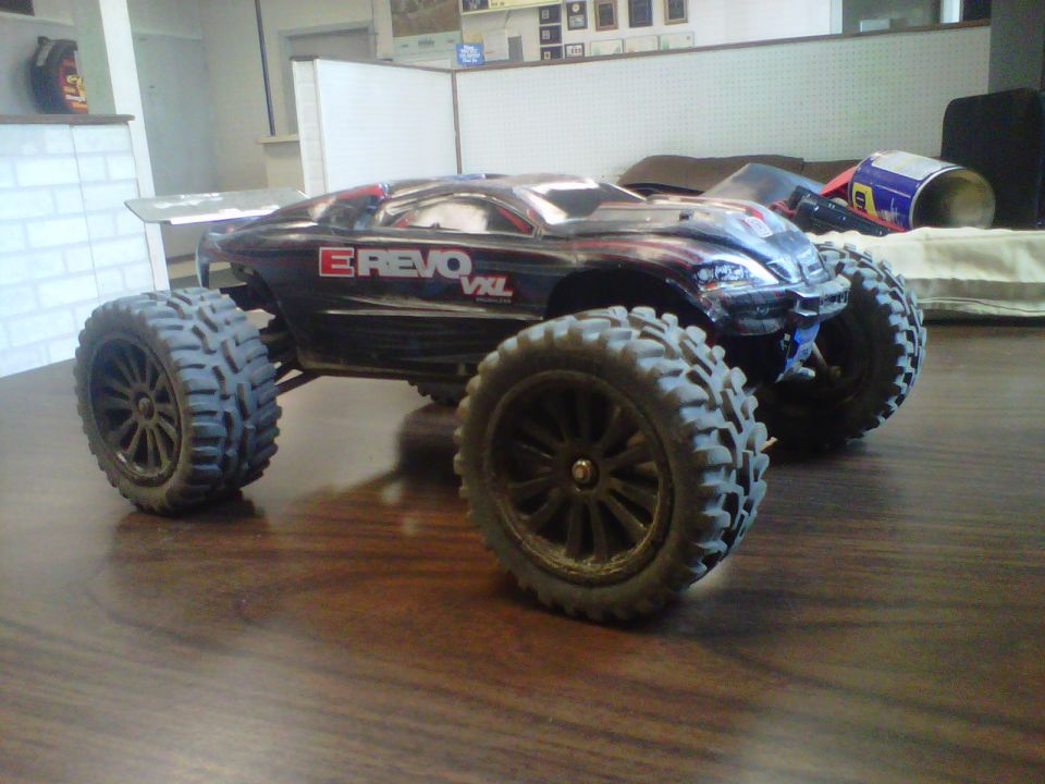 Black RC monster truck with E-Revo VXL graphics on a wooden surface