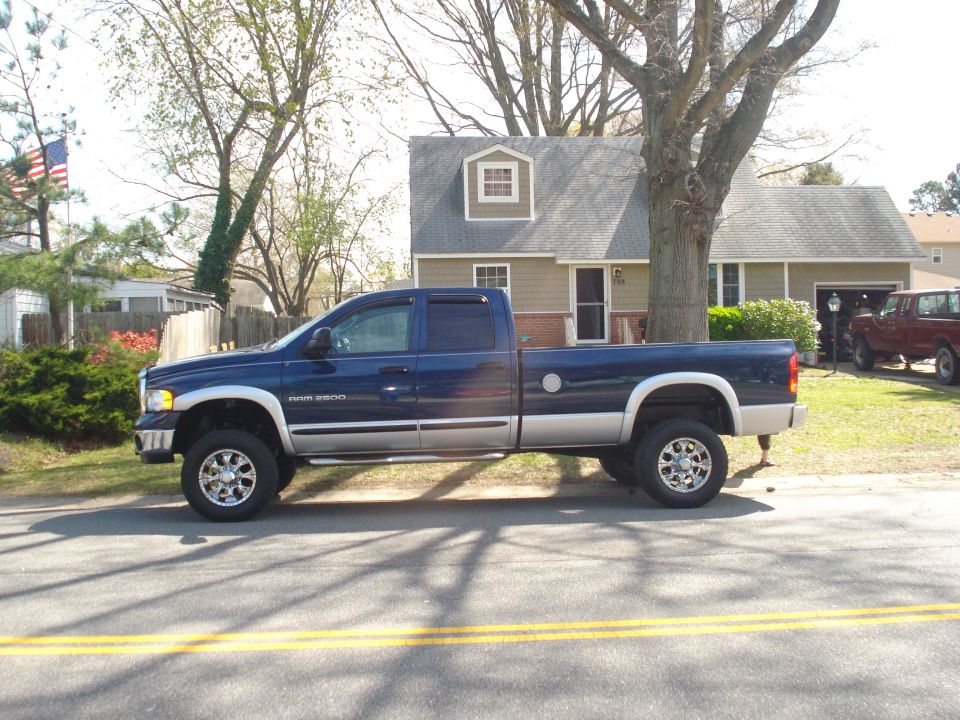 Blue Dodge Ram 2500 pickup truck, two-tone paint, chrome wheels, parked on street