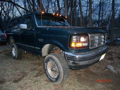 1993 Ford Bronco - This 1993 Ford Bronco is parked outdoors with trees in the background.