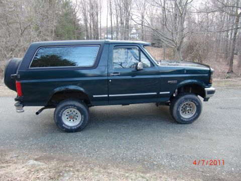 1993 Ford Bronco - This 1993 Ford Bronco is shown from the side, with a spare tire on the back and a sun visor above the windshield.