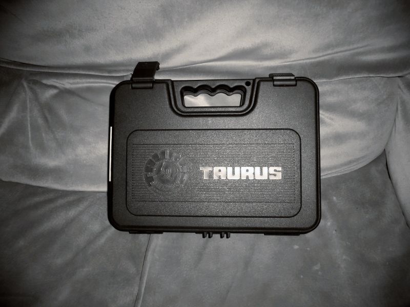 Black Taurus gun case with silver lettering on a gray fabric surface