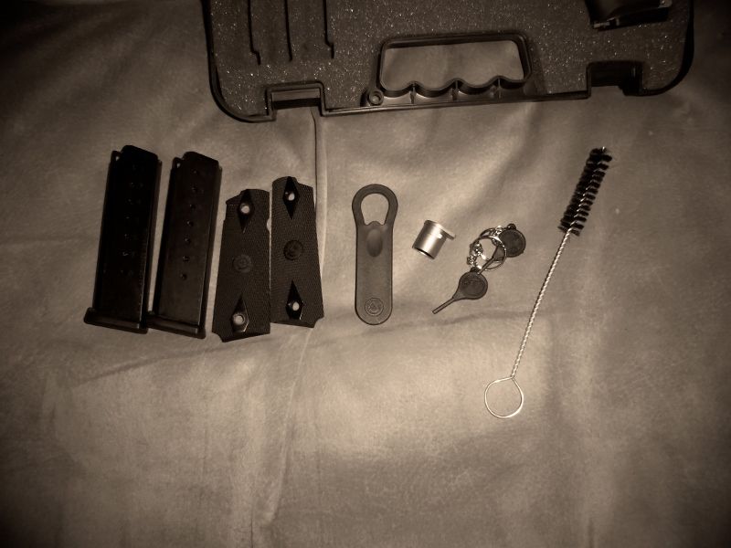Gun cleaning kit with brushes, keys, and magazines