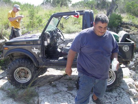1973 Ford Bronco - Two men with a Suzuki Samurai off-roading on a rocky trail.