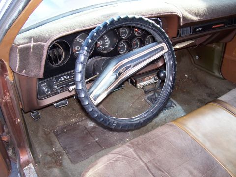 1972 Ford Ranchero - The interior of a 1972 Ford Ranchero shows its brown dashboard, steering wheel, and seats, with a floor shifter visible.
