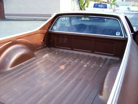 1972 Ford Ranchero - The bed of a 1972 Ford Ranchero shows its brown paint and ribbed floor. A second vehicle is visible in the background.