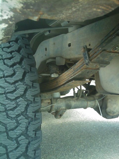 1994 Ford Bronco - Close-up view of the undercarriage, focusing on the rear suspension components and tire.