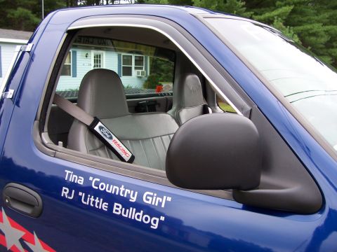 1998 Ford F-150 - The interior of a blue Ford F-150 truck shows custom text on the door and a Ford Racing seatbelt cover.