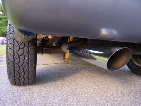 1998 Ford F-150 - The underside of a truck shows a large chrome exhaust pipe and a portion of the rear tire.