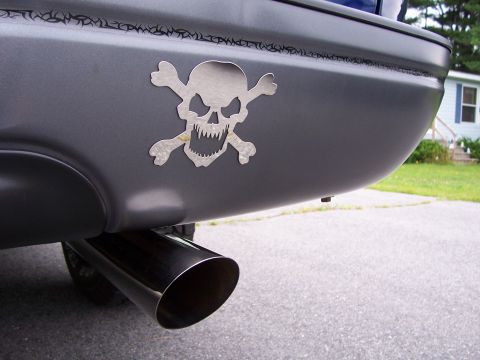 1998 Ford F-150 - A custom skull and crossbones sticker adorns the rear bumper of a vehicle, next to a large exhaust pipe.