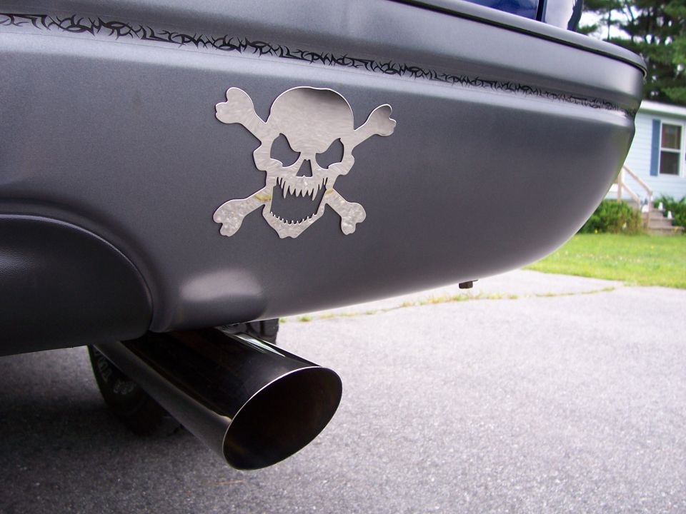 Gray rear bumper with skull and crossbones sticker and large exhaust pipe